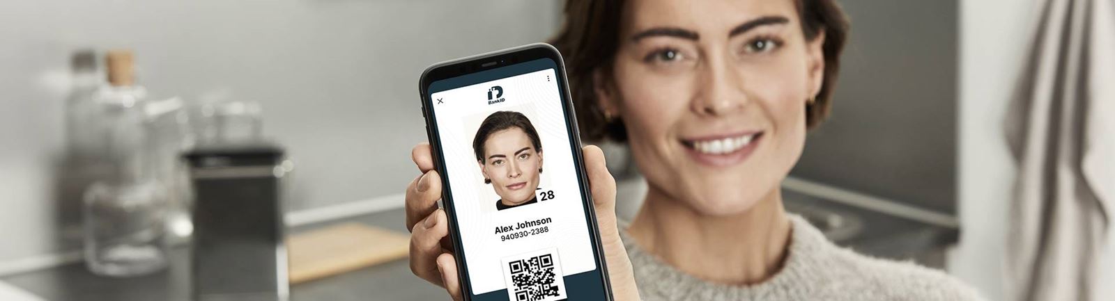 Kvinna visar upp ett digitalt ID-kort från BankID i sin mobil