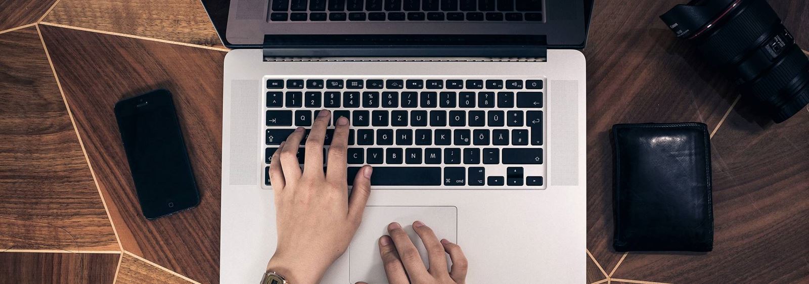 Två händer skriver på en laptop
